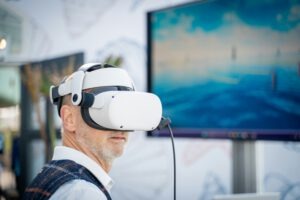 Ein Messebesucher trägt eine VR-Brille und testet ein interaktives Erlebnis am Messestand – ein Beispiel für Gamification im Messebau.