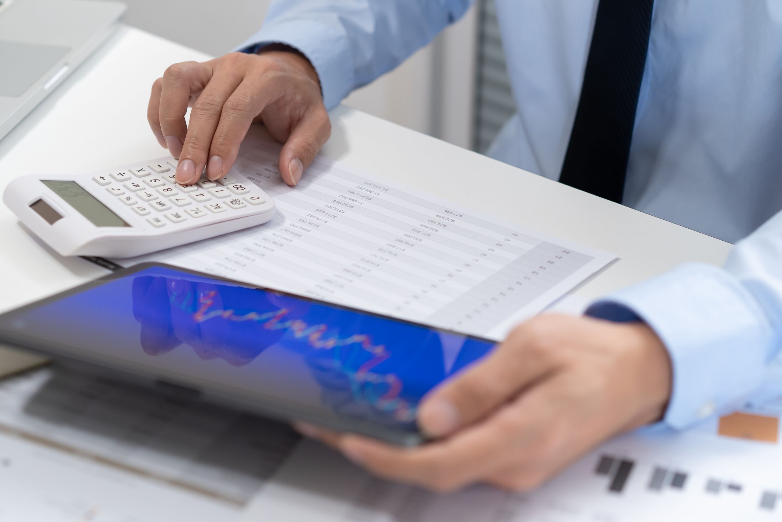 Ein Mann analysiert Diagramme und berechnet Umsätze – Symbol für Messenachbereitung mit System.